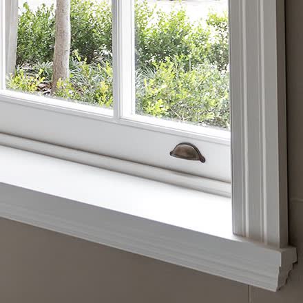 Six-over-six sash window with stepped casing — close-up of the details